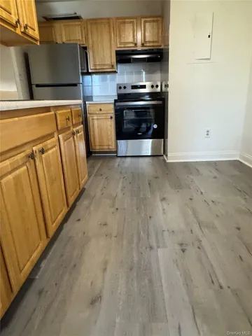a kitchen with granite countertop a refrigerator and a stove top oven