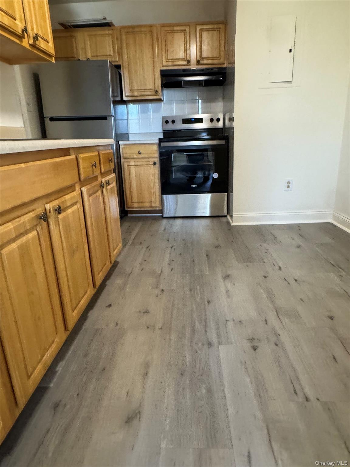155 Main Street, Unit 1 Beacon, NY 12508 - Photo 8 of 11 a kitchen with granite countertop a refrigerator and a stove top oven