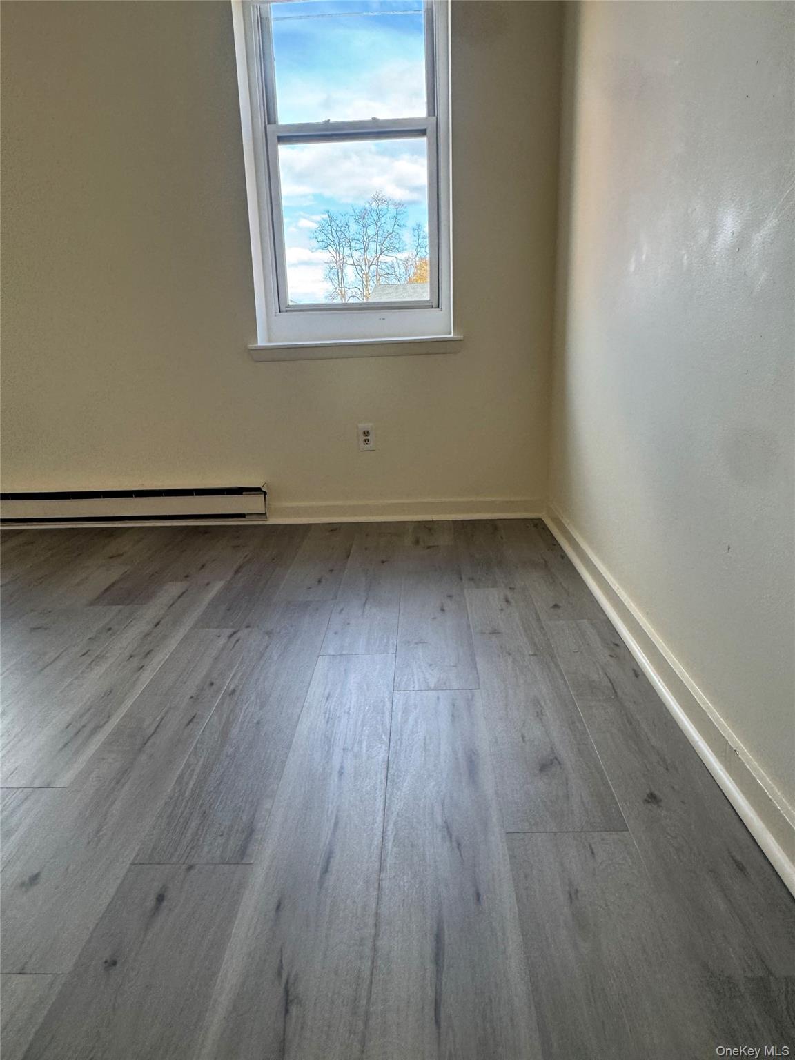 155 Main Street, Unit 1 Beacon, NY 12508 - Photo 9 of 11 an empty room with wooden floor and windows