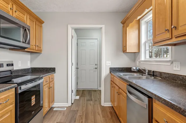 a kitchen with stainless steel appliances granite countertop a sink stove and microwave