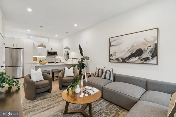 a living room with furniture kitchen and a table