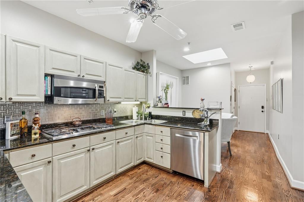 5264 Brooke Ridge Drive Dunwoody, GA 30338 - Photo 23 of 47 a kitchen with stainless steel appliances granite countertop a stove a sink and white cabinets