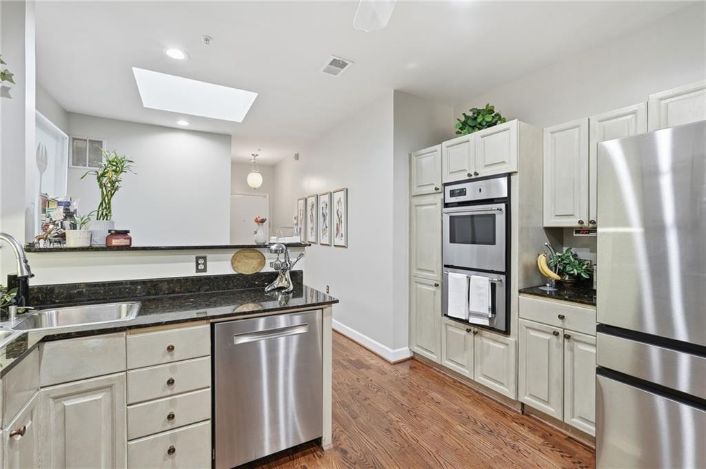 5264 Brooke Ridge Drive Dunwoody, GA 30338 - Photo 25 of 47 a kitchen with white cabinets and stainless steel appliances