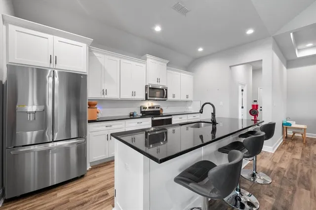 a kitchen with stainless steel appliances granite countertop a refrigerator and a stove top oven
