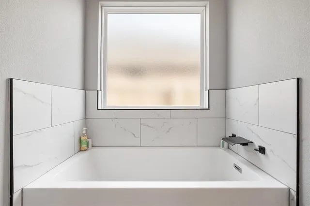 a spacious bedroom with a bed and a chandelier