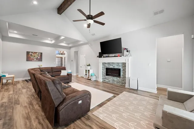 a living room with furniture a fireplace and a flat screen tv