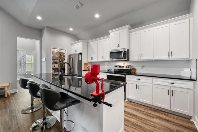 a kitchen with granite countertop a refrigerator stove and sink