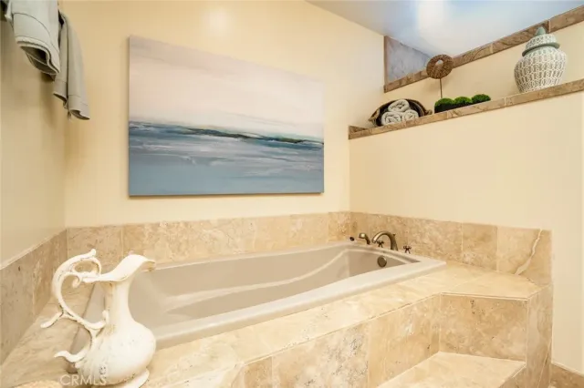 a en suite bathroom with a granite countertop tub and a sink