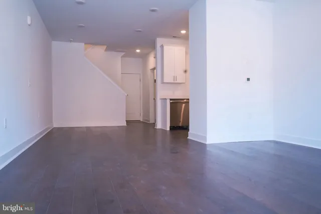 an empty room with a kitchen and a sink