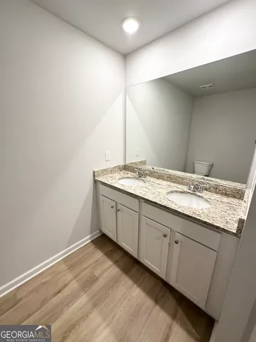 a bathroom with a granite countertop sink and white cabinets