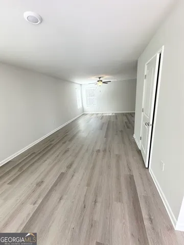 a view of empty room with wooden floor
