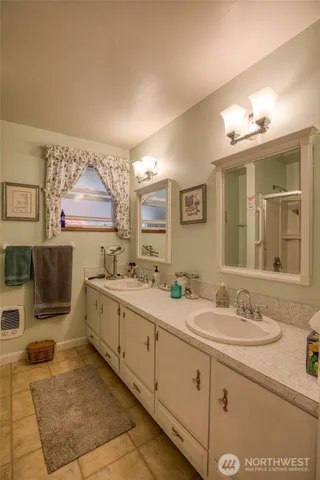 a spacious bathroom with a double vanity sink a mirror and a bathtub