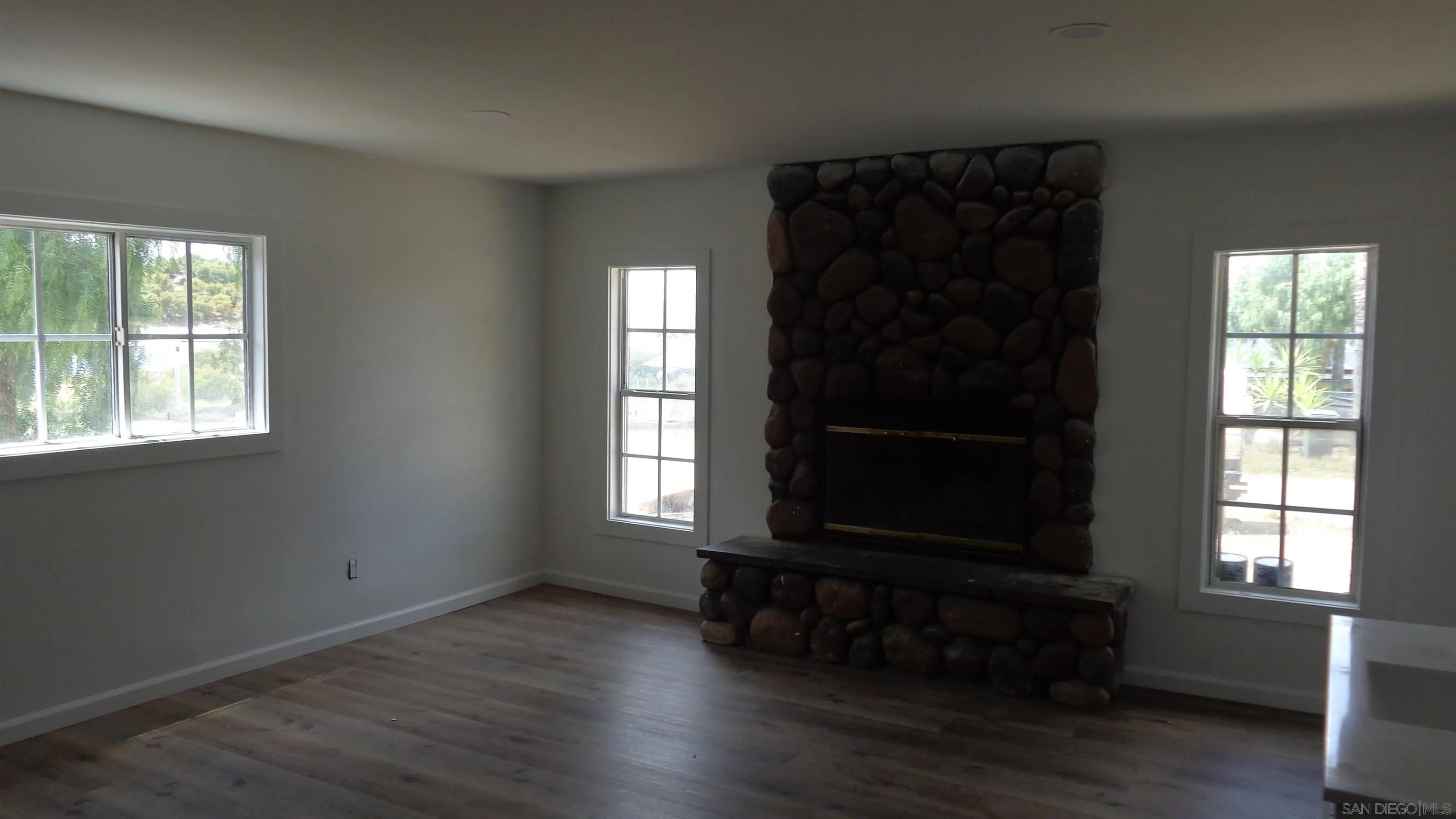 29660 Wilkes Road Valley Center, CA 92082 - Photo 1 of 16 an empty room with wooden floor windows and backyard