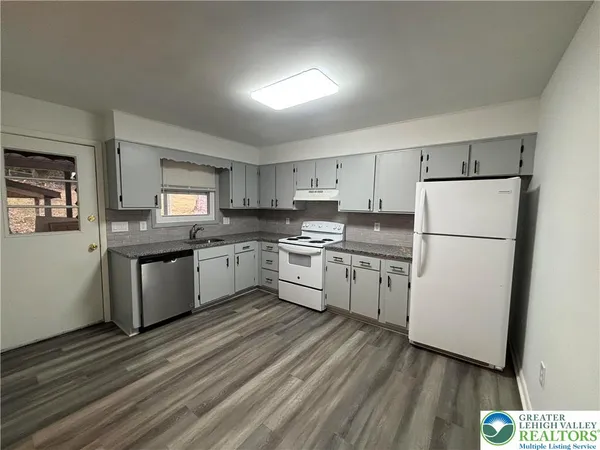 a kitchen with granite countertop white cabinets and white appliances