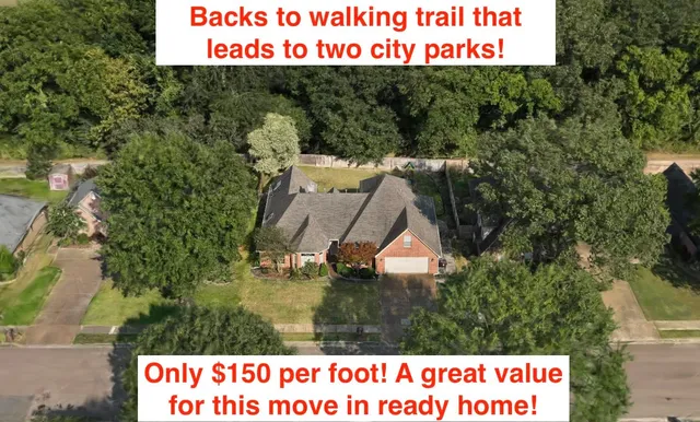 a view of a house with a yard and large tree