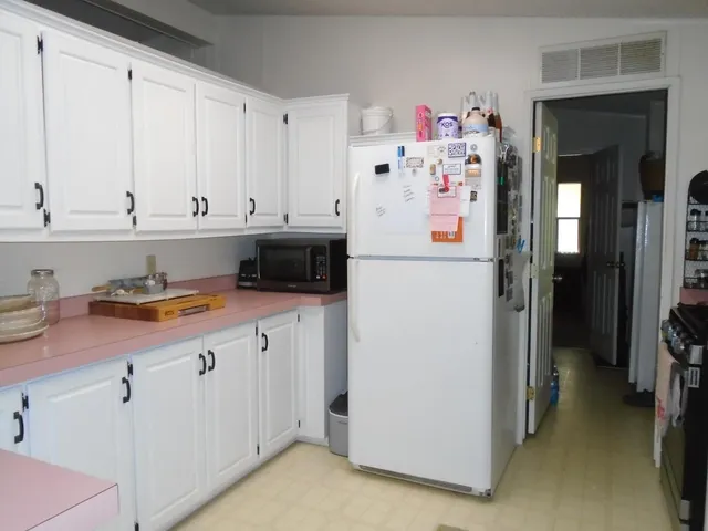 a kitchen with refrigerator and cabinets