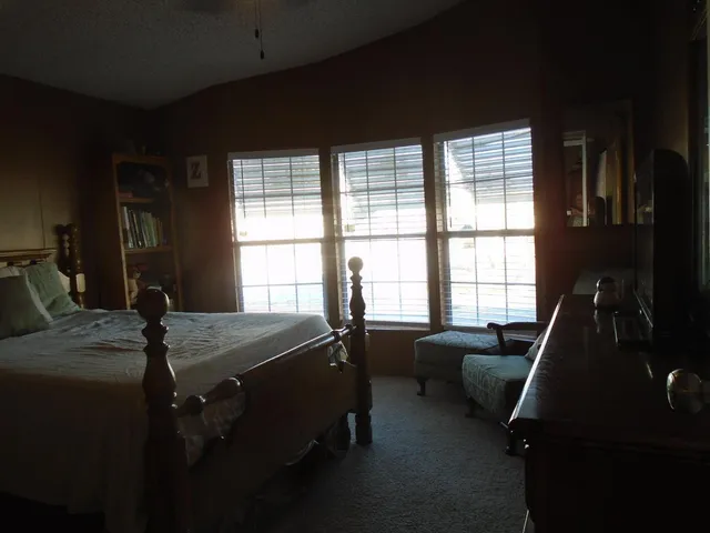 a bed sitting in a bedroom next to a window