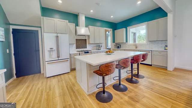 a kitchen with stainless steel appliances a dining table chairs and granite counter tops