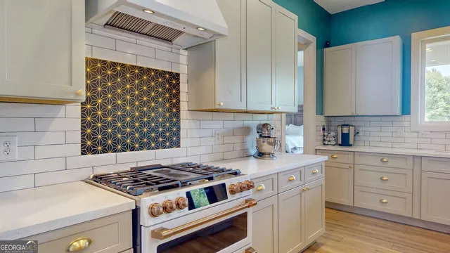 a kitchen with white cabinets and appliances
