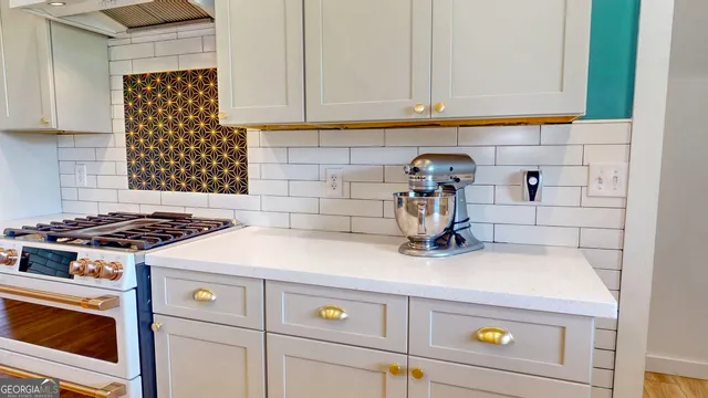 a kitchen with a stove and white cabinets