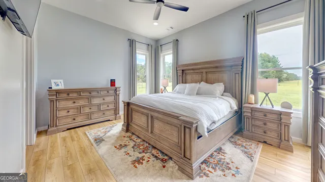 a bedroom with a bed a dresser and next to a window