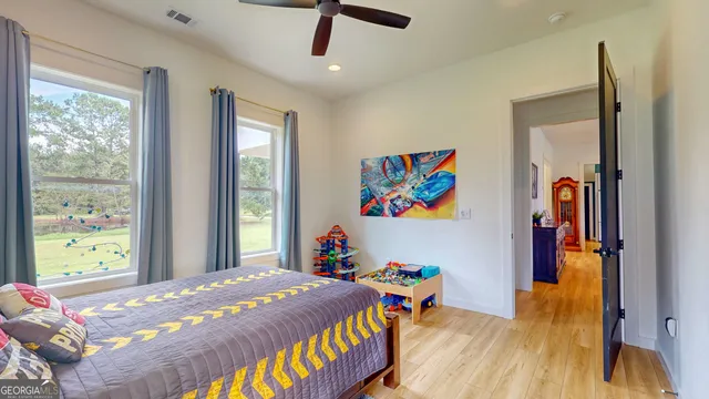a bedroom with a bed and a dresser next to a window