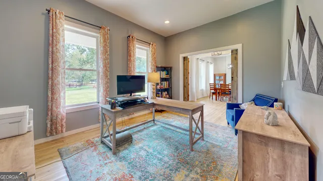 a living room with furniture a window and a flat screen tv