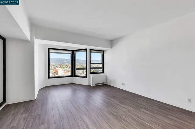 a view of an empty room with a window and a fireplace