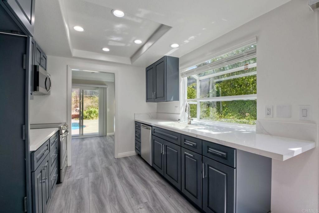 6428 El Perico Lane Carlsbad, CA 92009 - Photo 11 of 35 a kitchen with a sink and wooden floor