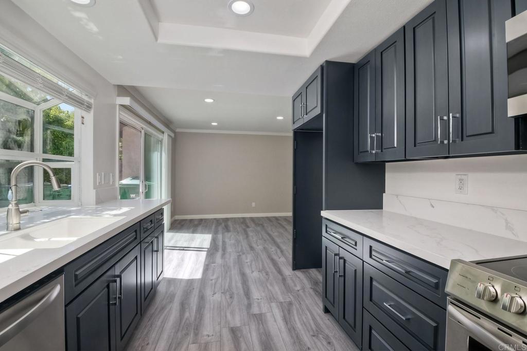 6428 El Perico Lane Carlsbad, CA 92009 - Photo 13 of 35 a kitchen with granite countertop a sink stove and cabinets