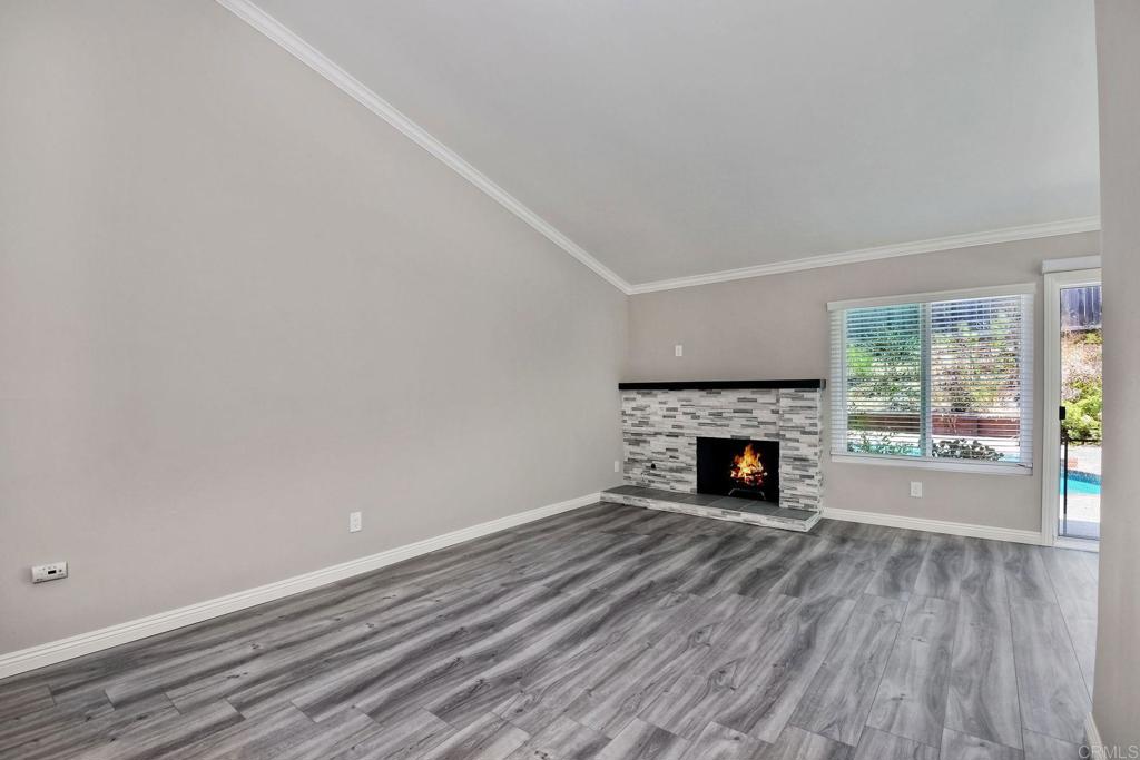 6428 El Perico Lane Carlsbad, CA 92009 - Photo 21 of 35 a view of a livingroom with a fireplace wooden floor and window