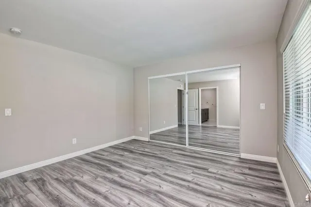 a view of a room with wooden floor and white walls
