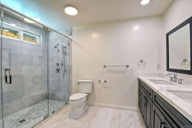 a bathroom with a granite countertop sink toilet and shower