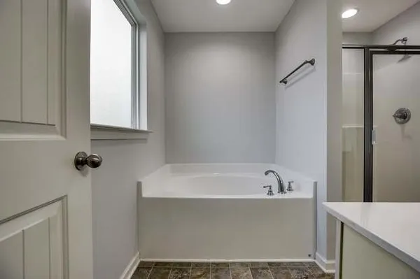 a bathroom with a bathtub and a window