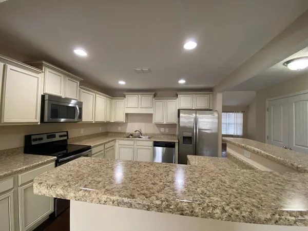 a kitchen with stainless steel appliances granite countertop a sink stove and refrigerator