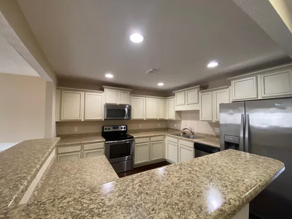 a kitchen with stainless steel appliances granite countertop a sink stove and refrigerator