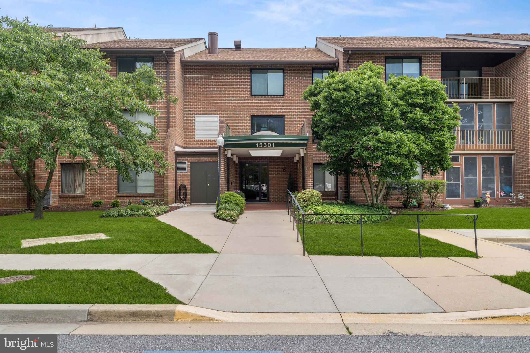 a front view of a house with a yard and garden