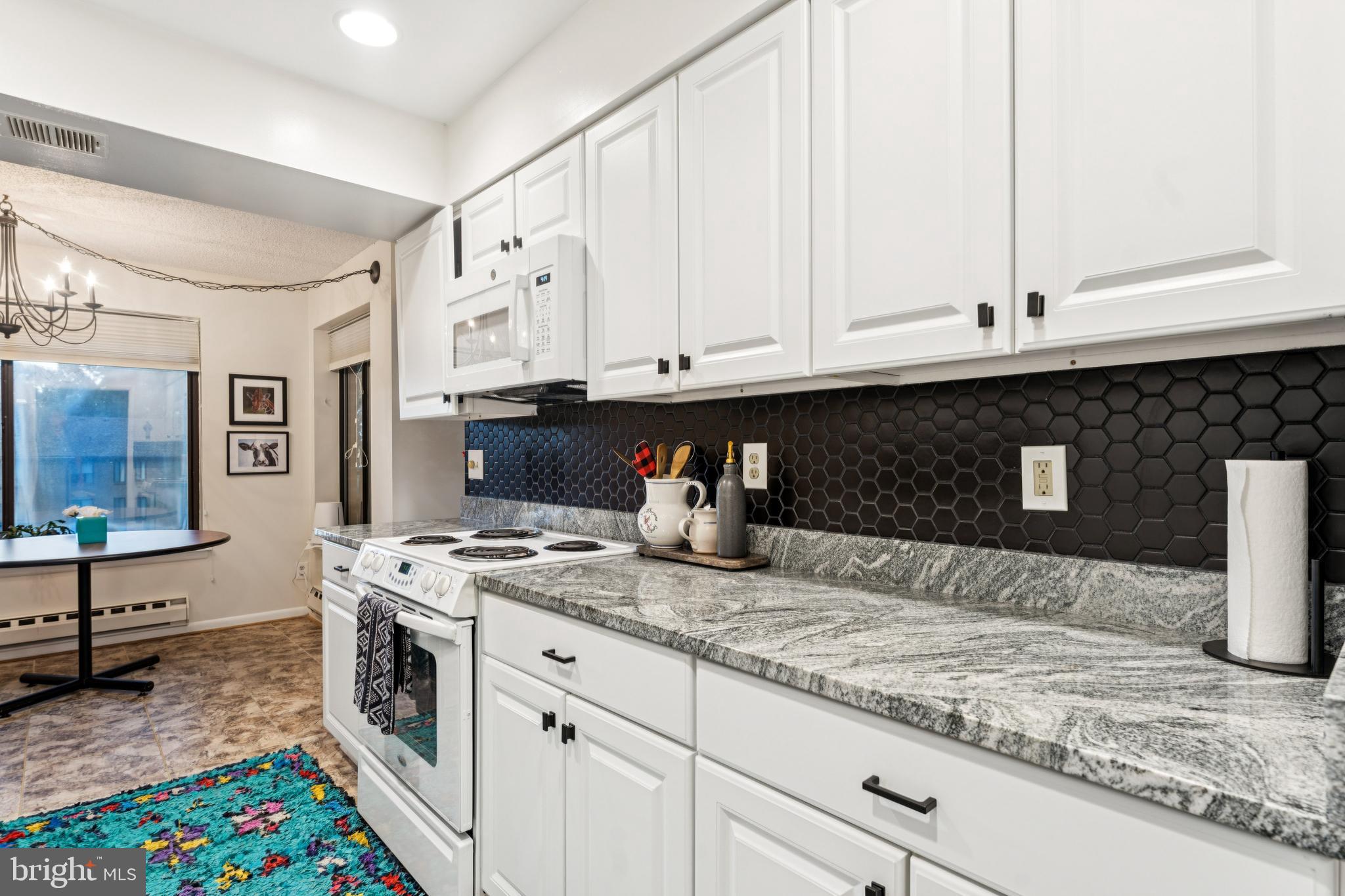 15301 Beaverbrook Court, Unit 923K Silver Spring, MD 20906 - Photo 7 of 25 a kitchen with granite countertop a sink stainless steel appliances and cabinets