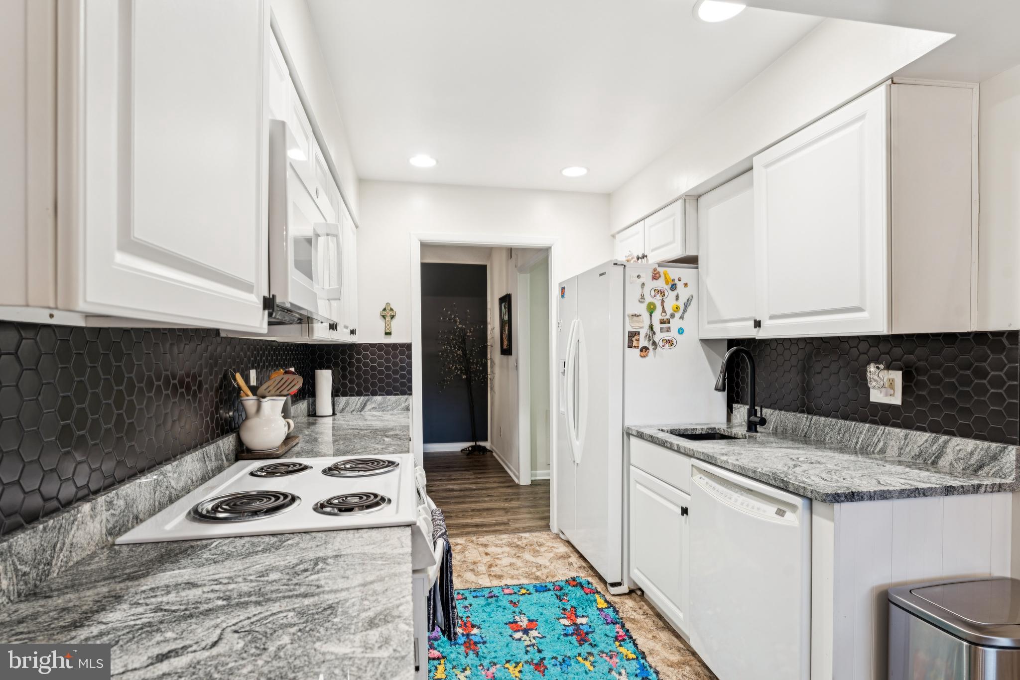 15301 Beaverbrook Court, Unit 923K Silver Spring, MD 20906 - Photo 8 of 25 a kitchen with a stove a sink and a refrigerator
