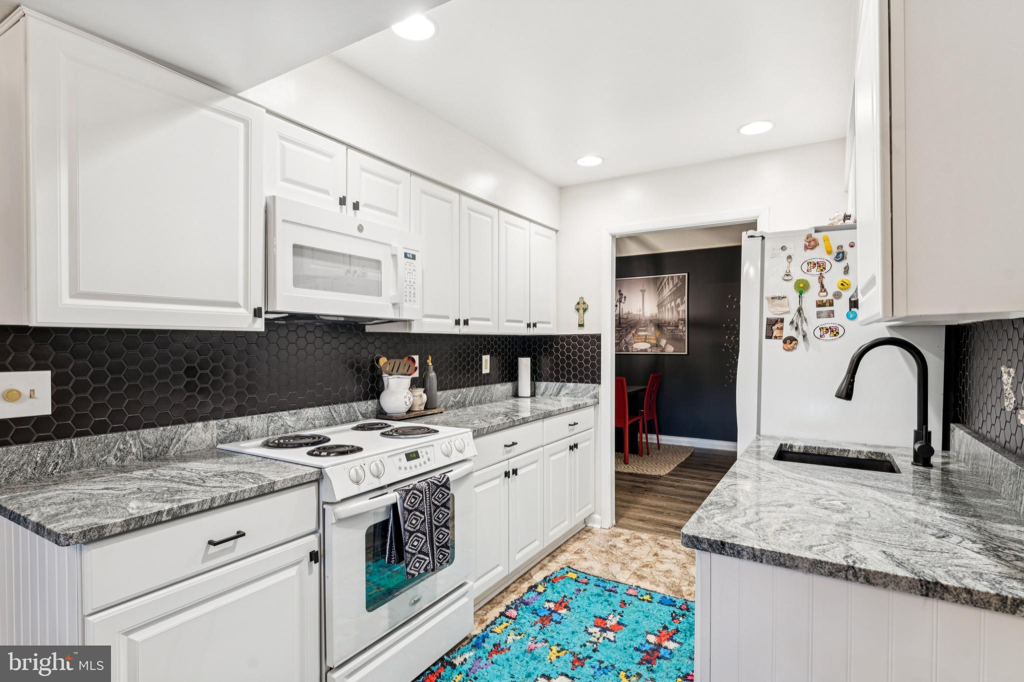15301 Beaverbrook Court, Unit 923K Silver Spring, MD 20906 - Photo 9 of 25 a kitchen with stainless steel appliances granite countertop a stove a sink and a refrigerator