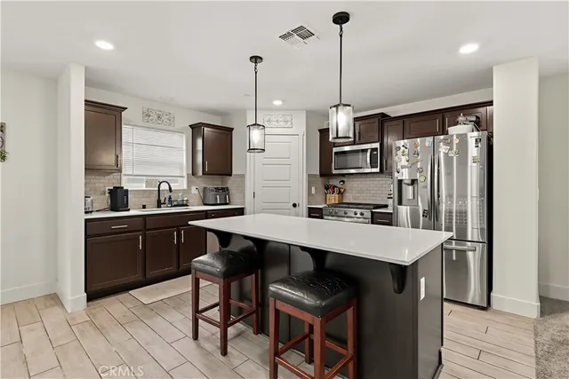 a kitchen with a refrigerator a sink and chairs