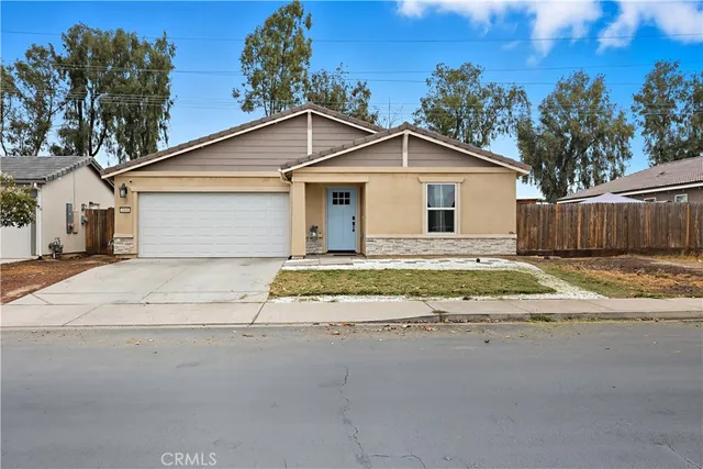 a view of a house with a yard and large trees