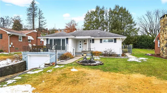 a front view of a house with a garden and lake view