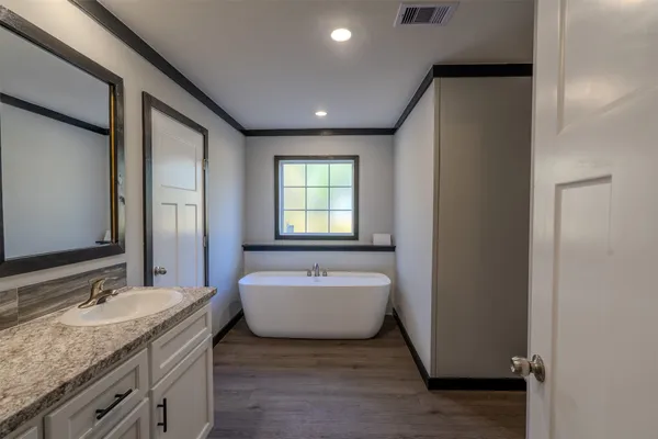 a spacious bathroom with a double vanity sink and a bathtub