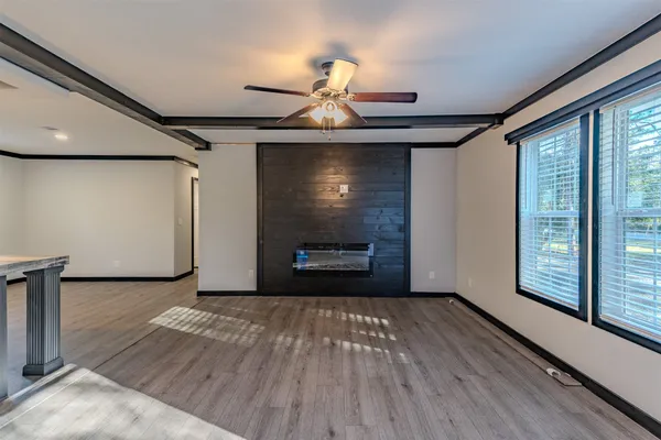 a view of wooden floor fire place and windows in a room