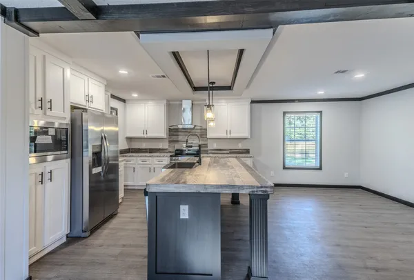 a kitchen with stainless steel appliances granite countertop a refrigerator a sink a stove and oven