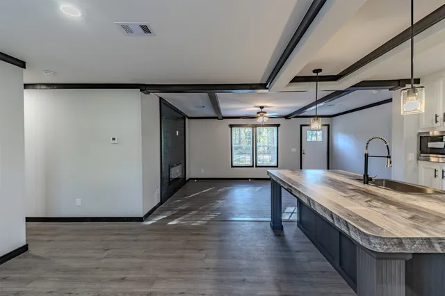 a view of a kitchen with a sink dishwasher and wooden floor
