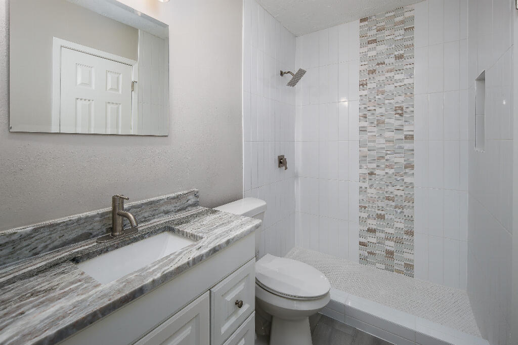 64 Cross Creek Road, Unit 20 Miramar Beach, FL 32550 - Photo 16 of 19 a bathroom with a granite countertop sink a toilet and a mirror