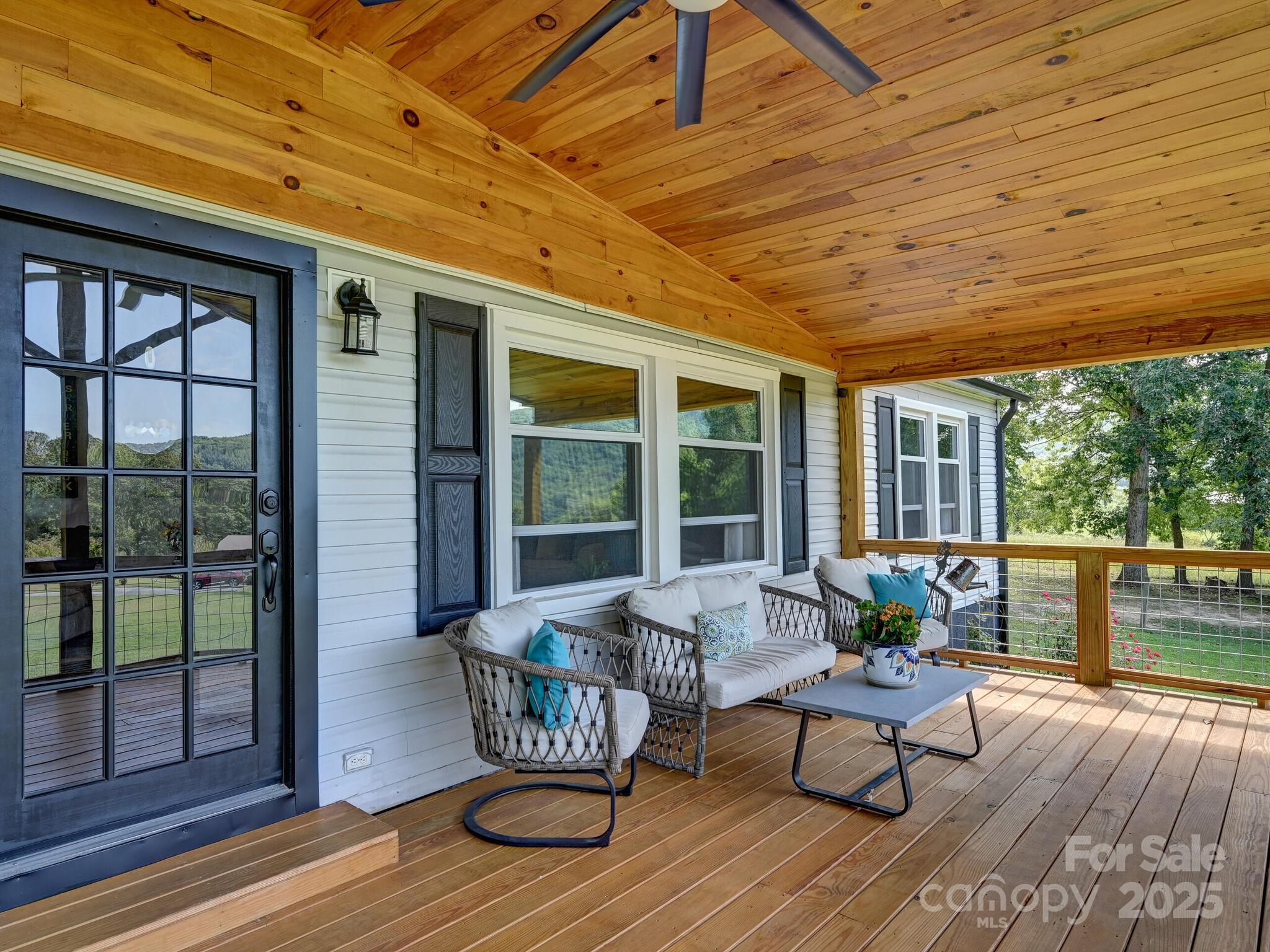 450 Berry Wills Road Hot Springs, NC 28743 - Photo 3 of 48 a view of a patio with table and chairs and wooden floor