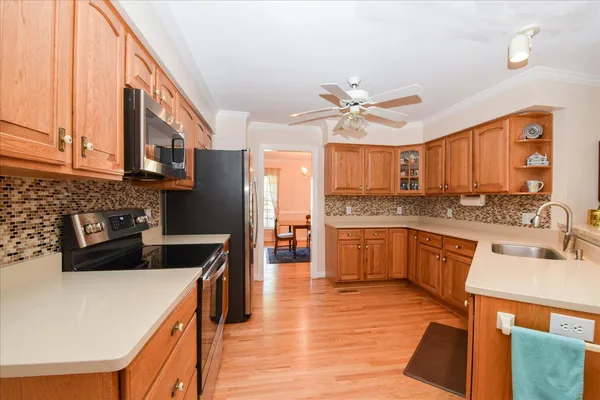 a kitchen with a sink a counter top space stainless steel appliances and cabinets